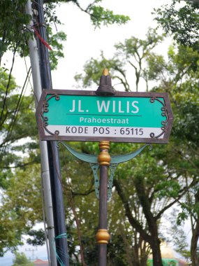 Malang, Indonesia -18 February, 2023 : street name sign in Malang city with a unique colonial design with Jalan Wilis or Prahoestraat written in Dutch