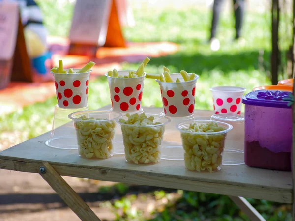 Patates kızartması ve kızarmış makarna, festivallerde yol kenarında plastik bardaklarda satılıyor.