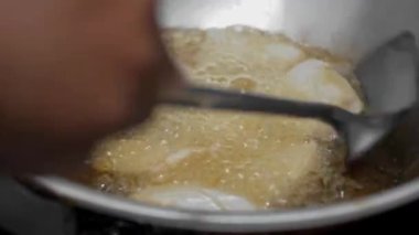 Kızarmış tofuyu bir spatulayla tavanın üzerine çevir ki eşit derecede pişsin.