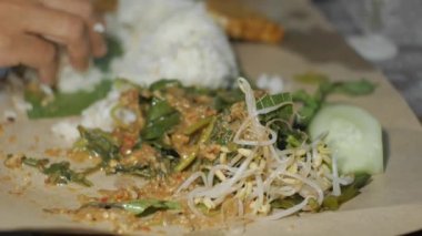 Pekel pilavı, fasulye filizi, hardal yeşili, fıstık soslu salatalık ve yanında tempeh ve kraker gibi sebzelerden oluşan geleneksel bir Endonezya yemeğidir.