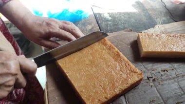 Yapışkan pirinç ve hindistan cevizinden yapılan tipik bir Endonezya pastası, yani wingko, satılmadan önce küçük karelere bölünür.