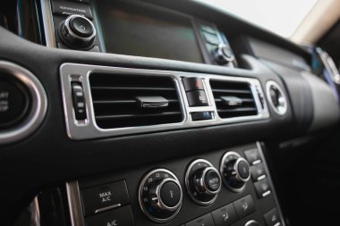 Havalandırma ızgarası ve kontrol düğmeleri olan araçtaki gösterge paneli.