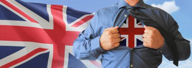 Bir iş adamı tişörtünü İngiltere bayraklı süper kahraman gibi açıyor ve bir tişörtün altına bastırılmış bayrağını göstererek ne kadar vatansever olduğunu gösteriyor..