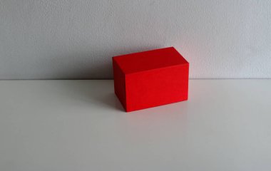 Kapalı kırmızı kağıt kutu beyaz ahşap masa üzerine yerleştirildi.