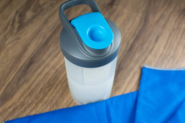 Drink for fitness and sports. A shaker, a microfiber towel, and a tracker watch.