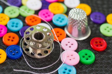 Dikiş malzemeleri - kumaş düğmeleri, yüksük, iğne, iplik makaraları.