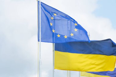 Ukrayna ve Avrupa Birliği 'nin bayrakları gökyüzüne karşı dalgalanıyor. Avrupa 'nın birleşmesi.