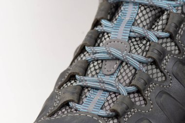 Lacing of trekking boots, close-up. Hiking boots isolated on white background.