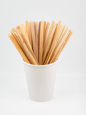 Wooden sticks for stirring a coffee drink in a disposable cup.