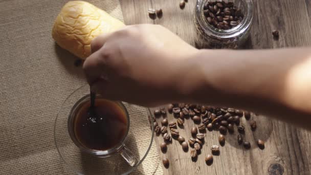 澄んだコーヒーカップとコーヒー豆でコーヒーを作る人々 上から見ると暖かい光の中で古い木の上でパン — ストック動画