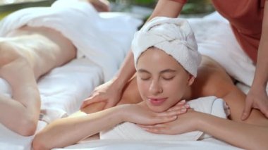 Beautiful young woman receiving arm and shoulders  massage relaxing in spa salon, Close-up young women enjoying massage, Outdoor spa in gardens and natural light.