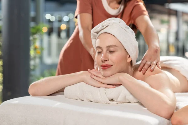 Beautiful young woman receiving arm and shoulders  massage relaxing in spa salon, Close-up young women enjoying massage, Outdoor spa in gardens and natural light.