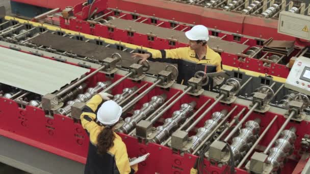 男工程师和女工程师戴安全帽检查工厂的机械 顶视图 — 图库视频影像