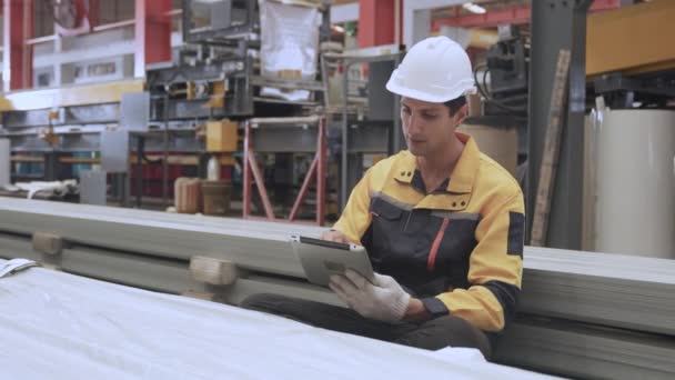 직업적인 공장에 엔지니어 헬멧을 착용하는 노동자 체크리스트 문서를 보유하는 기계장치 — 비디오