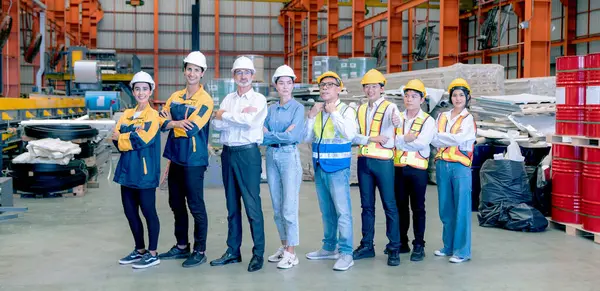 Portrait of confident team of factory workers standing in warehouse. Transportation and distribution warehouse. Industrial,engineering and industrial workers concept.
