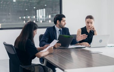 İş adamlarından oluşan bir grup başarılı takım çalışması ve iş konsepti toplantılarının sonuçlarını ofisteki grafikleri ve grafikleri tartışıyor..