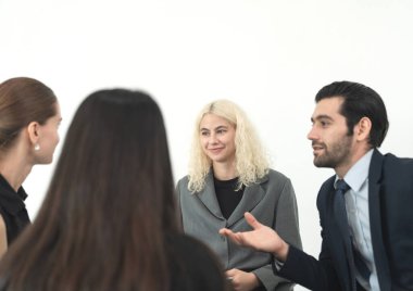 Bir grup profesyonel modern ofis ortamındaki toplantı sırasında aktif olarak fikirleri tartışıyor..