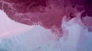 Yüksek Akıcı Akışkan Boyama. Dalgalanan parıltılı yüzey. Güzel metalik pembe, mor, leylak desenli yakın plan boya. Sıvı ağır çekim sanatı. Renkli Kaos Türbülansı. Soyut Renkli Tasarım.