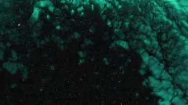 Dalgalanan parıltılı yüzey. Akan Altın soyut zemin. Güzel metalik yeşil desenli boya yakın plan. Sıvı ağır çekim sanatı. Renkli Kaos Türbülansı.