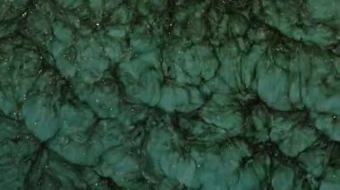 Mor arka planda dönen yeşil boya. Pembe duman ve bulutların makro videosu. Soyut fantezi akışkan sanat arka planı.