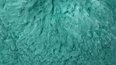 Mor arka planda dönen yeşil boya. Pembe duman ve bulutların makro videosu. Soyut fantezi akışkan sanat arka planı.