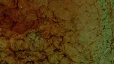 Kahverengi kıvrımlı duman uzak bir evrene benzer. Alkollü mürekkep karışımı. Akışkan sanat çizimi videosu, renkli dalgalı soyut akrilik doku. Parçacık arkaplanı altında sıvı. 