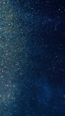 Soyut derin boya, parıltı yayıyor. Alkol mürekkebiyle soyut sanat arkaplan tasarımı. Petri kabındaki boyanın kimyasal reaksiyonunun makro videosu. Mavi Işıltılı Altın Parçacıklar.