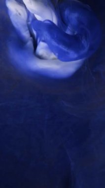 Yavaş hareket eden sıvı renkli mürekkep. Boya suya dökülüyor. Siyah arka planda mürekkep bulutu. Suya soyut mürekkep damlaları..