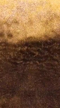 Resimler hareket halindeyken soyut, yakın plan. Parlak sanat dinamik sıvı mürekkebi. Parıldayan doku. Suluboya sıvı arka plan. Dikey video arkaplanı.