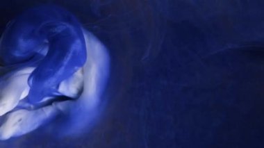 Yavaş hareket eden sıvı renkli mürekkep. Boya suya dökülüyor. Siyah arka planda mürekkep bulutu. Suya soyut mürekkep damlaları..