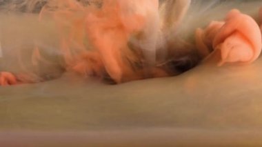 Canlı turuncu ve sarı dokulardan oluşan bir yatağın üzerinde dumanın narin kıvrımını yakalayan yakın plan bir görüntü..