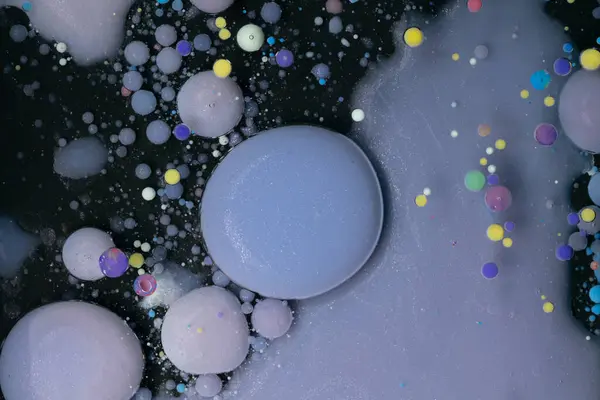 stock image A myriad of oil droplets intermingling with water, creating a mesmerizing effect reminiscent of a galaxy.