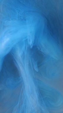 Mavi mürekkep suda karışıp soyut desenler oluşturur..