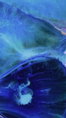 Çarpıcı sanatsal bir süreç kıvrımlı mavi ve yeşil renklerle ortaya çıkar, dinamik soyut desenler yaratır. Renklerin karışımı dikkatleri çeker ve yaratıcılığa ilham verir..