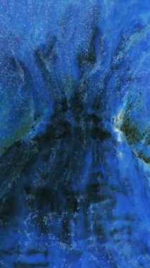 Bir sanatçı, renkli mürekkepleri ustalıkla harmanlayarak karmaşık bir soyut sanat eseri oluşturur. Güzel mavi renkler ve dinamik desenler izleyicilerin ilgisini çeker..