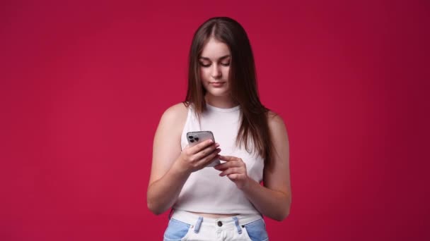 Vídeo Cute Woman Using Phone Isolated Red Background Conceito Tecnologia — Vídeo de Stock