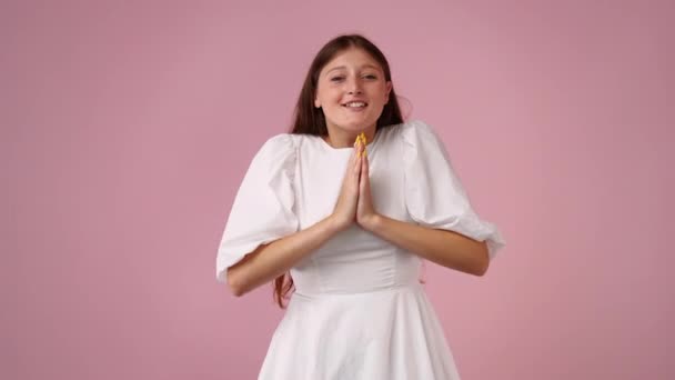 Видео Взволнованной Молодой Женщины Хлопающей Ладоши Прыгающей Через Розовый Фон — стоковое видео