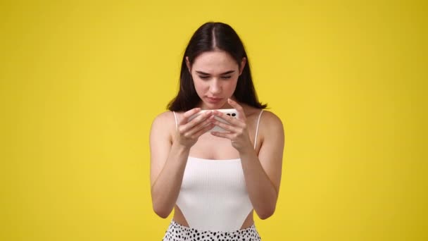 Video Van Leuke Vrouw Kijken Naar Iets Haar Telefoon Geïsoleerd — Stockvideo