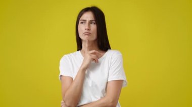 Pembe arka plan üzerinde düşünen genç bir kadının 4K videosu..