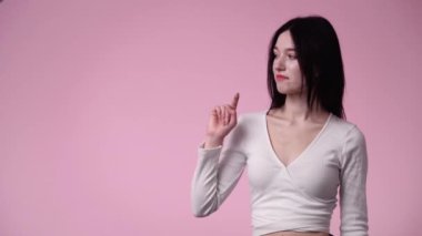 Pembe arka planda izole edilmiş üzgün bir kadının 4K videosu. Olumsuz duygular konsepti.