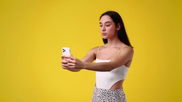 Sarı Arka Planda Izole Edilmiş Selfie Çeken Genç Bir Kadının — Stok video