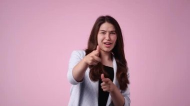 Heyecanlı bir kadının pembe arka planda baş parmağını kaldırdığı 4K videosu. Memnuniyet kavramı.