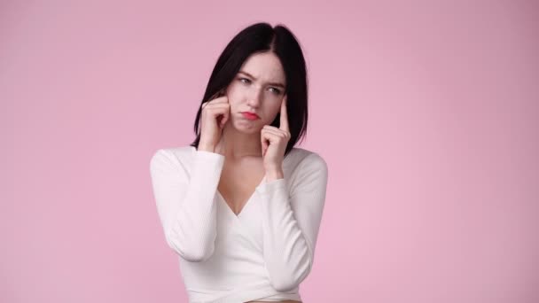 ピンクを背景に頭痛の種が隔離された若い女性の4K動画 感情の概念 — ストック動画