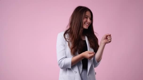 4Kビデオの興奮した若い女性ダンス上のピンクの背景 コンペットの喜び — ストック動画