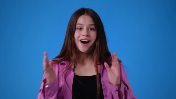 興奮した女の子が青い背景で手に拍手しているの4Kビデオ 拍手の概念 — ストック動画