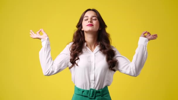 黄色い背景で瞑想している1人の女の子の4Kビデオ 感情の概念 — ストック動画