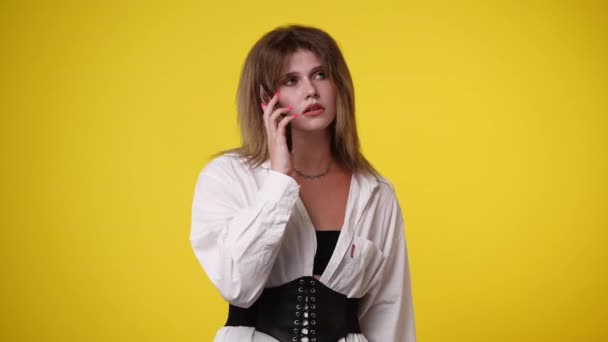 Video Una Chica Hablando Por Teléfono Sobre Fondo Amarillo Concepto — Vídeo de stock