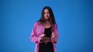 Mavi arka planda dans eden kızın 4K videosu. Duyguların kavramı.