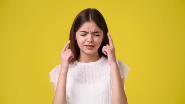 Video Niña Tocando Sus Sienes Con Los Dedos Fondo Amarillo — Vídeos de Stock