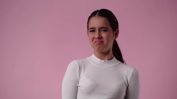 4K视频 一个女孩在粉色背景下展示大拇指 负面情绪的概念 — 图库视频影像